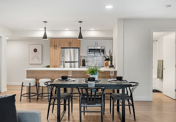 A modern dining room with a table set for four.at Skyway Apartments, Calgary, AB T3B 5V6