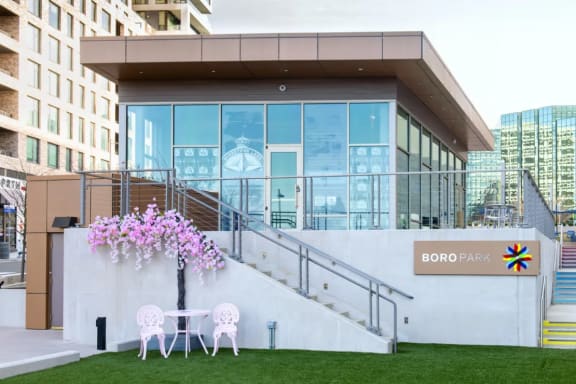 a patio with chairs and a table in front of a building