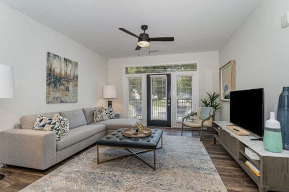 a living room with a couch and a ceiling fan