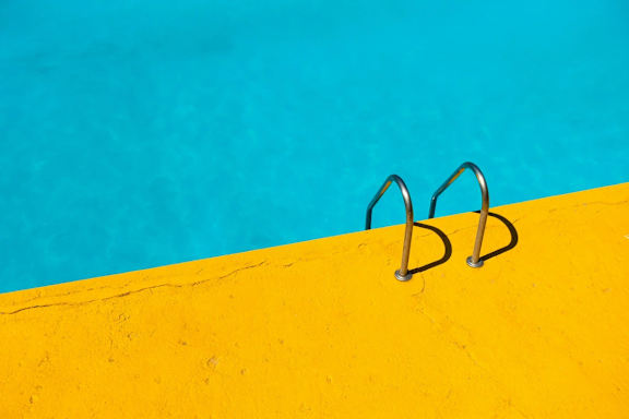 Two metal rings are attached to a yellow wall.