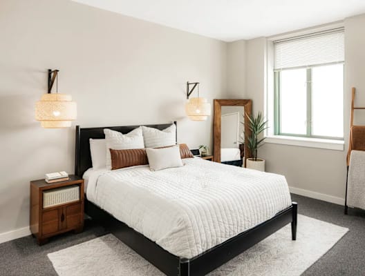 a bedroom with a bed and two windows