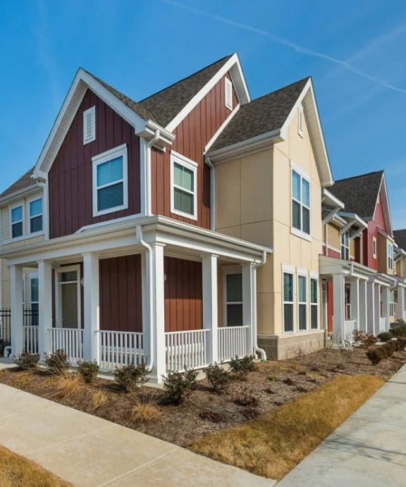 a row of houses with a sidewalk in front of them