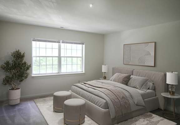 A bedroom with a large bed, a potted plant, and a framed picture on the wall.