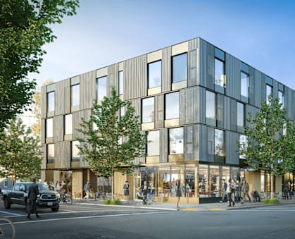 A modern building with a lot of windows and trees in front.