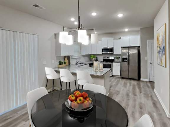 A modern kitchen with a glass table and white chairs.