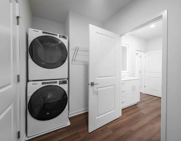 A white washing machine is in a small laundry room.