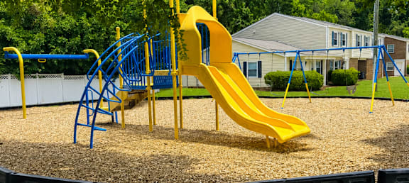 A playground with a yellow slide and blue play structure.