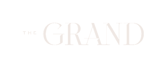 The image shows a logo with the words "THE GRAND" in white text on a black background.