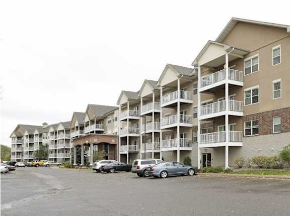 Apartment building with cars parked in front.