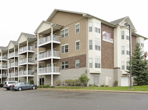 a picture of an apartment complex with cars parked in front of it