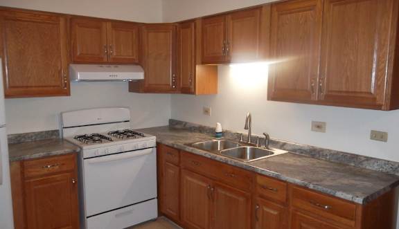Kitchen with a white stove and wooden cabinets.at The Countryside, Illinois, 60525
