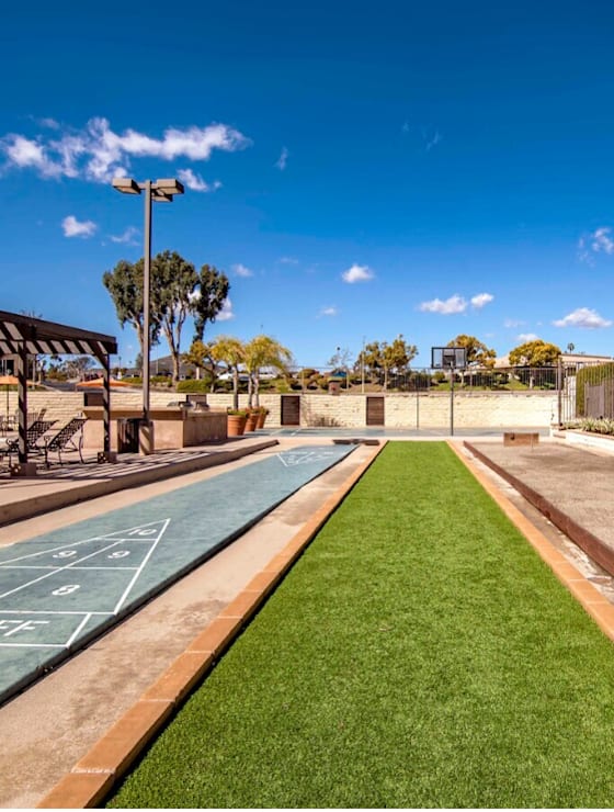 a basketball court in a park next to a road