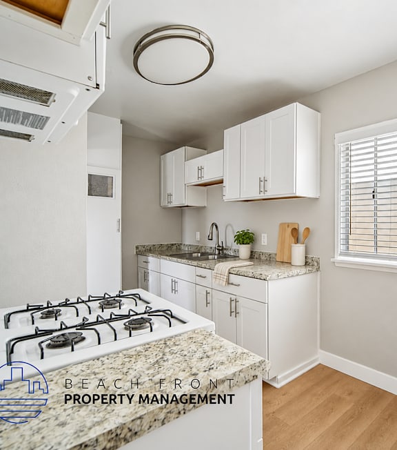 A kitchen with a granite countertop and white cabinets.