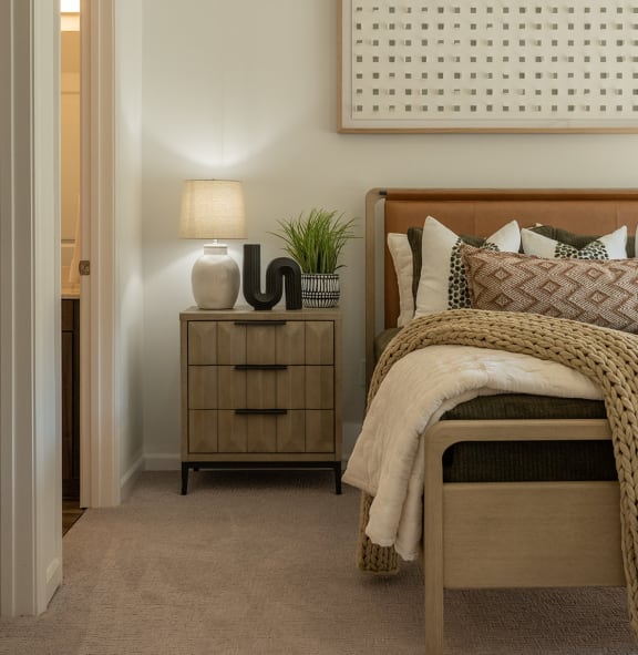 a bedroom with a bed and two nightstands with lamps and  at The Clearing at ONE28, Olathe, KS