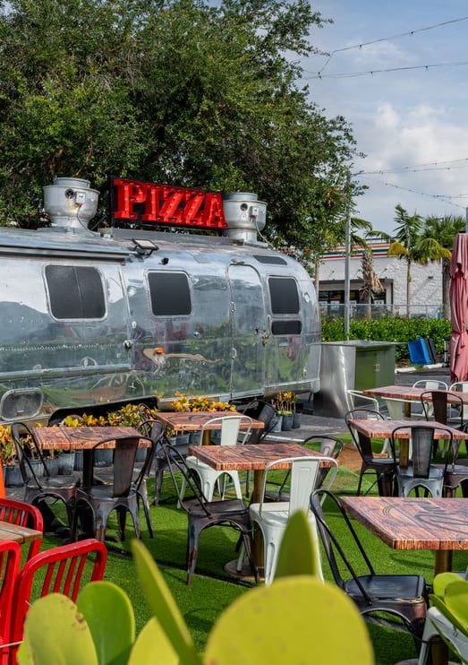 a train themed restaurant with tables and chairs and plants