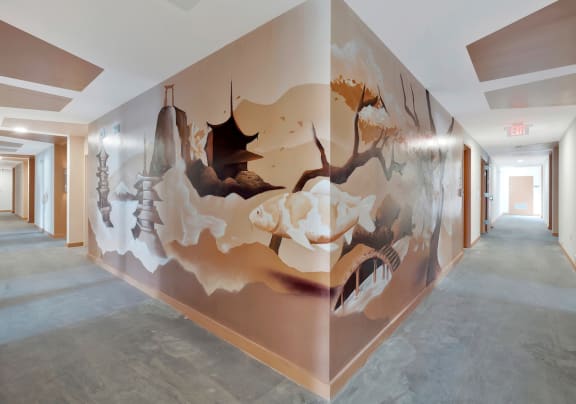 a residential hallway with a large mural of fish flying through a chinese landsacape on the wall at The Citizen Birmingham