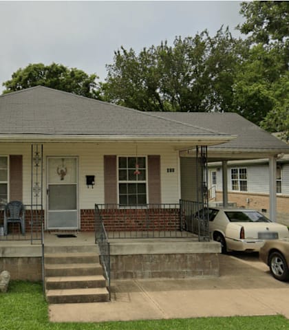 A house with a car parked in front.
