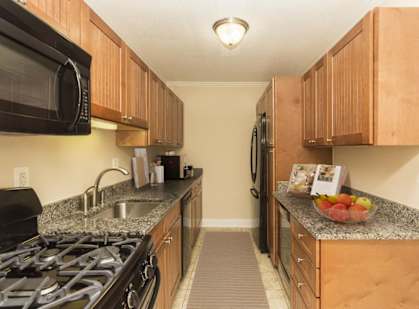 A kitchen with wooden cabinets and granite countertops.