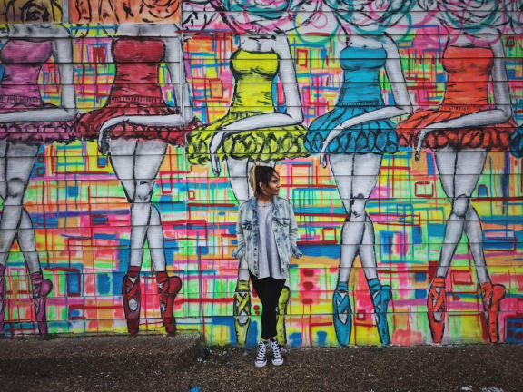 woman posing in front of a graffiti wall