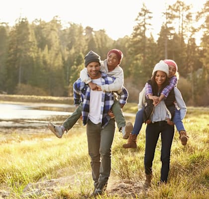 A family of four is walking through a field.
