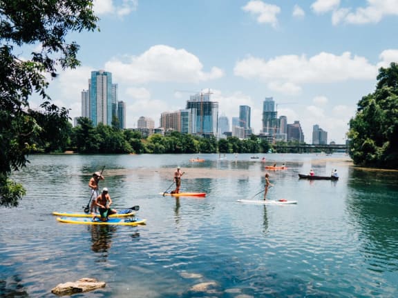 a group of people on kayaks on a lake with a city in the background