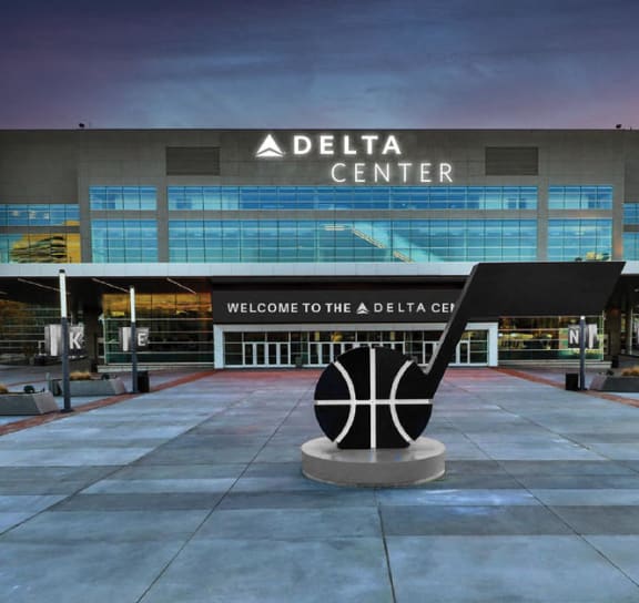 a sculpture in front of the delta center at dusk