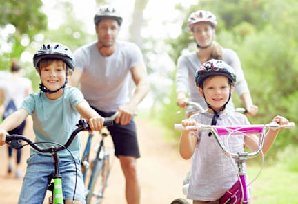 A group of people riding bikes on a dirt road.