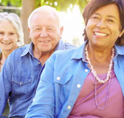 Four people sitting outdoors on a bench.