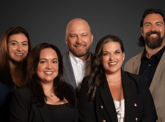 A group of five people are standing together.