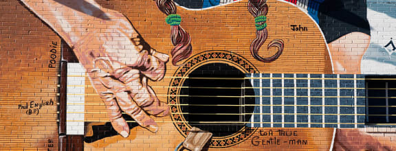 a mural of a horse and a guitar on a brick wall