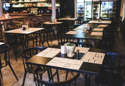 A restaurant with tables and chairs and a menu on the table.