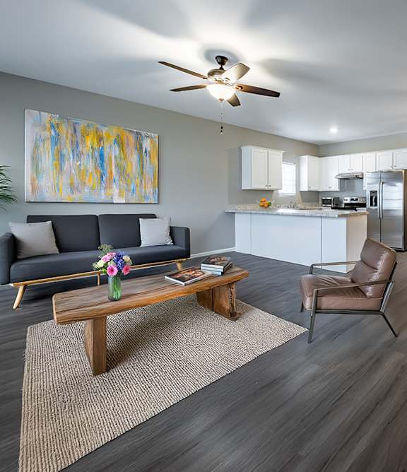 Modern living room with wooden floor and a large painting on the wall at Club Villas Apartments, Kathleen, GA, 31047