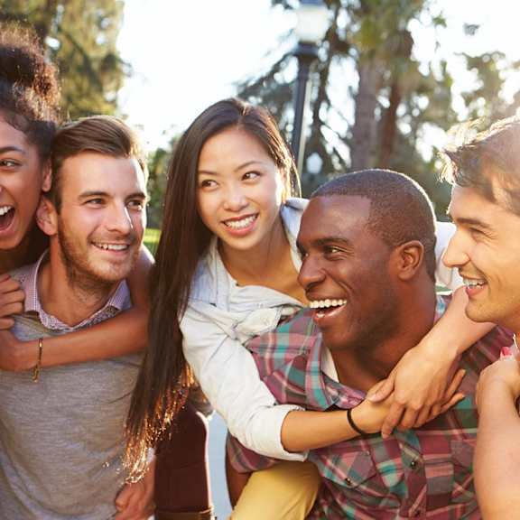 A group of friends are huddled together in a park.