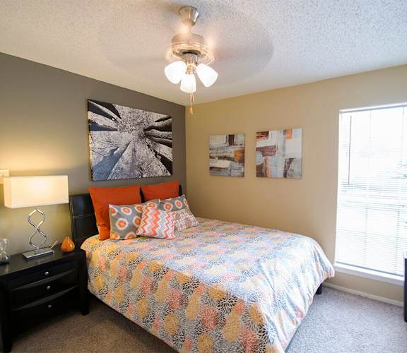 a bedroom with a bed and a ceiling fan