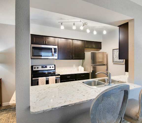 A kitchen with a marble countertop and modern appliances.