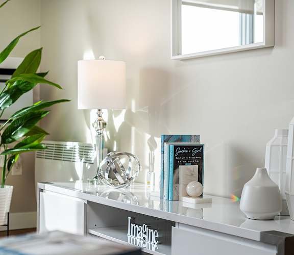 a console table with a lamp and other items on it