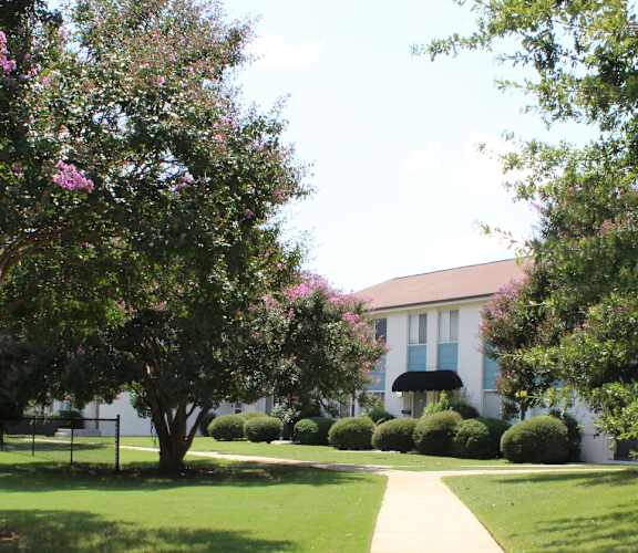 the neatly landscaped, tree-lined courtyard with walkways at Huntsville Landing Apartment homes for rent in Huntsville, AL