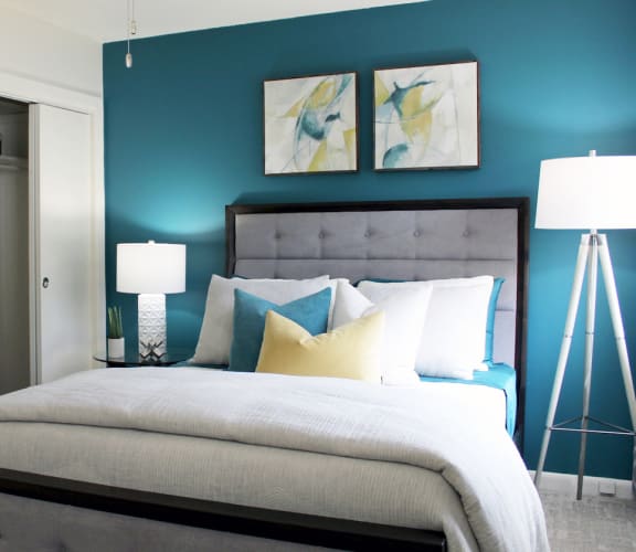 the model bedroom with a blue accent wall  at Huntsville Landing Apartments
