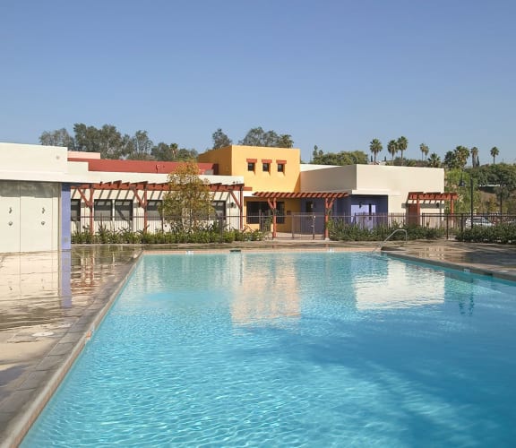Outdoor pool with apartment buildings at Pueblo del Sol