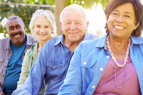 Three elderly people are sitting at a table in a restaurant.