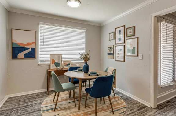 A dining room with a table set for four.