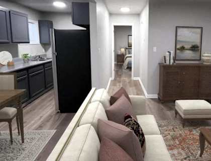 A modern kitchen with a black refrigerator and wooden floors. at Windmill, Indiana