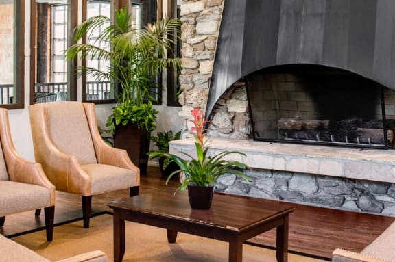 a living room with a fireplace and chairs and a coffee table