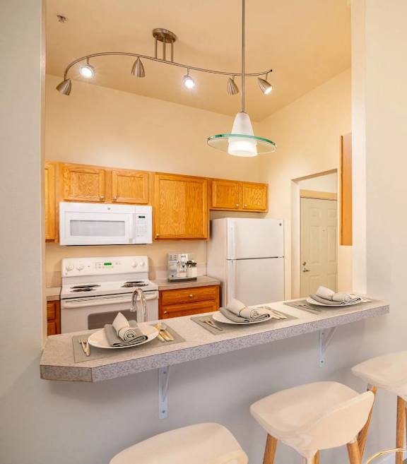 A kitchen with a white refrigerator, microwave, and oven. at Fairview Village Apartments, Fairview, Oregon
