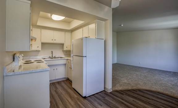 A kitchen with white appliances and cabinets.