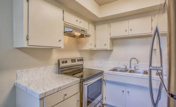 A kitchen with white cabinets and stainless steel appliances.
