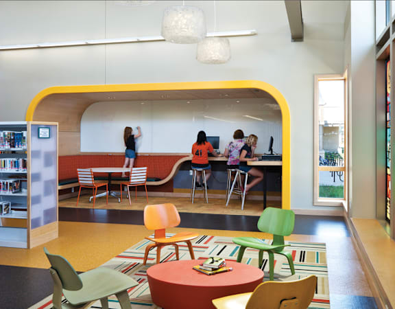 a group of people in a room with tables and chairs