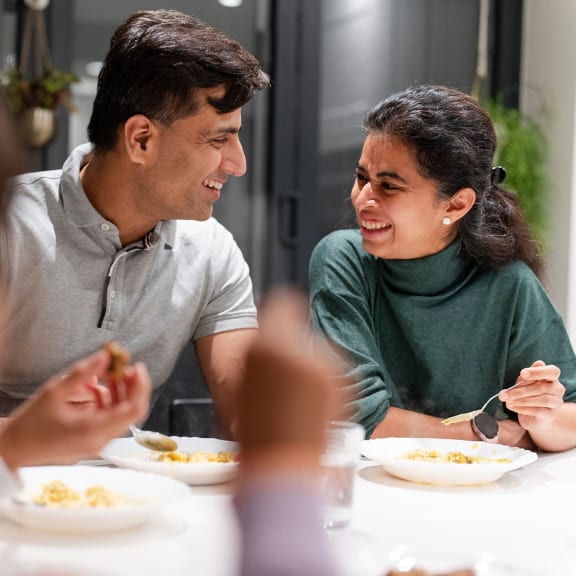 a man and woman sitting at a table eating food