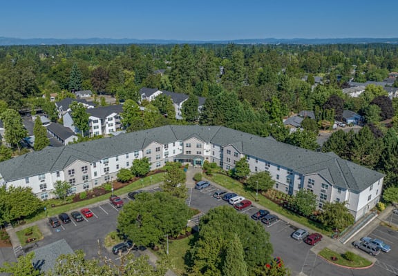 A large white building with a parking lot in front of it.