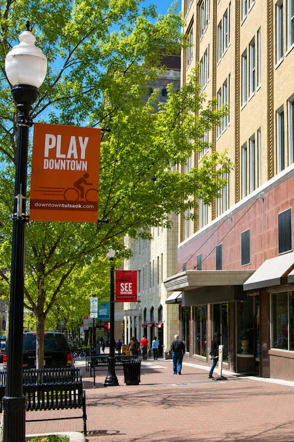 A sign that says Play Downtown is on a pole.